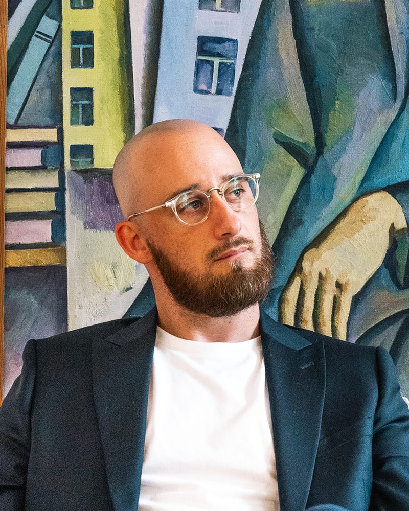 Stéphane Cornille sitting in front of a Soviet-era painting