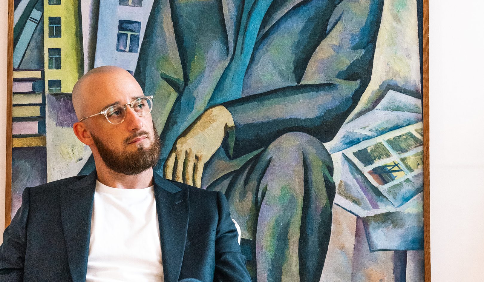 Stéphane Cornille sitting in front of a Soviet-era painting